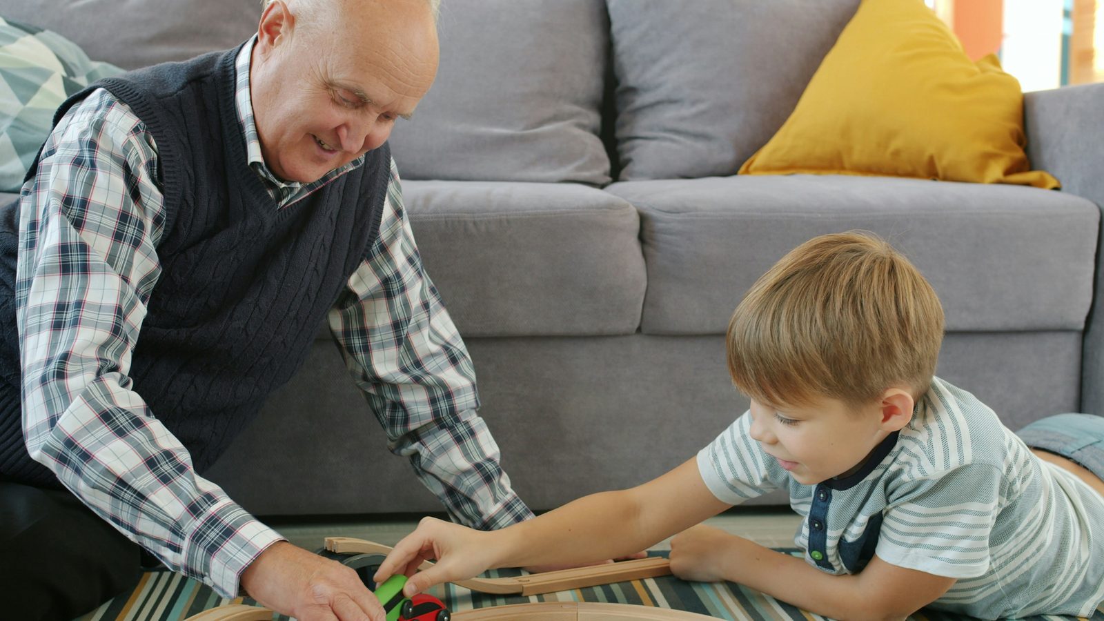 Grandfather and grandchild playing together on the floor at home